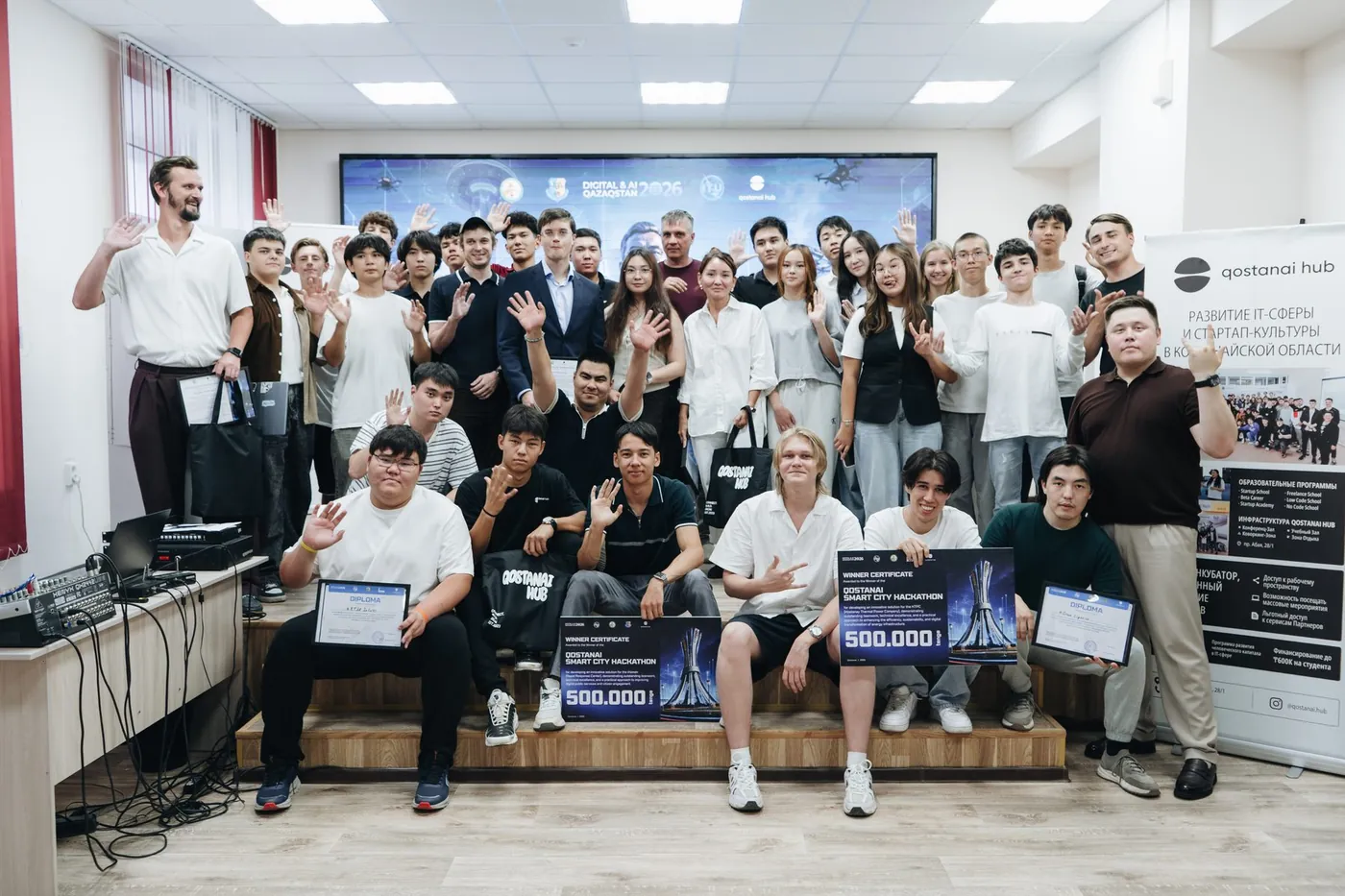 Команды, менторы и организаторы Qostanai Smart City Hackathon в зале после защит